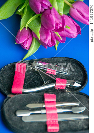 Tools and cosmetics needed for nail styling on a blue background. Pedicure set isolated on white. pink cosmetic bag and a set of women's accessories. High quality photo Tools and cosmetics needed for nail styling on a blue background. Pedicure set isolated on white. pink cosmetic bag and a set of women's accessories. High quality photo 141937076