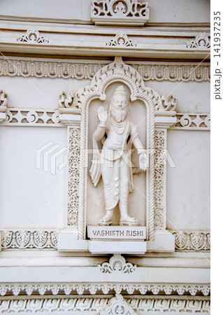 A white marble sculpture of a Hindu saint in the temple. Oldest temple in India. Beautiful sculpture of ancient India 13th century. Wall mounting background. Wall poster. A white marble sculpture of a Hindu saint in the temple. Oldest temple in India. Beautiful sculpture of ancient India 13th century. Wall mounting background. Wall poster. 141937235