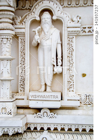 A white marble sculpture of a Hindu saint in the temple. Oldest temple in India. Beautiful sculpture of ancient India 13th century. Wall mounting background. Wall poster. A white marble sculpture of a Hindu saint in the temple. Oldest temple in India. Beautiful sculpture of ancient India 13th century. Wall mounting background. Wall poster. 141937237