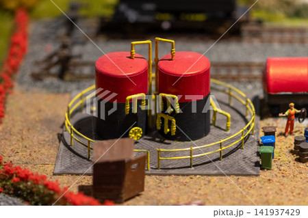Closeup of miniature industrial storage tanks with railings on model terrain Closeup of miniature industrial storage tanks with railings on model terrain 141937429
