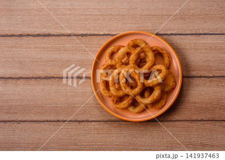 Deep fried breaded onion or squid rings, crispy fast food snacks. Fried onion or squid rings Deep fried breaded onion or squid rings, crispy fast food snacks. Fried onion or squid rings 141937463