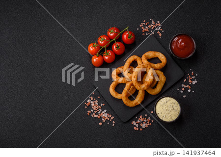 Deep fried breaded onion or squid rings, crispy fast food snacks. Fried onion or squid rings Deep fried breaded onion or squid rings, crispy fast food snacks. Fried onion or squid rings 141937464