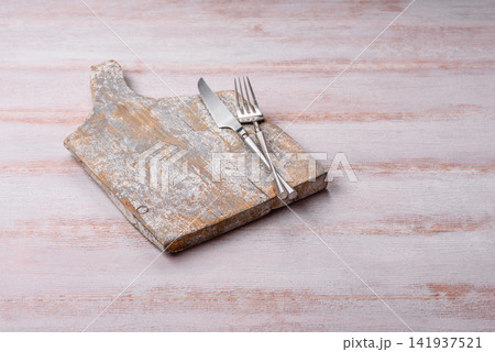 A square wooden cutting board for home food preparation. A wooden cutting board A square wooden cutting board for home food preparation. A wooden cutting board 141937521