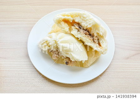 白いお皿にのせた半分に割った肉まん 白いお皿にのせた半分に割った肉まん 141938394