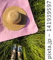 Summer flat lay. Picnic blanket, hat, woman legs on green grass. 141939597