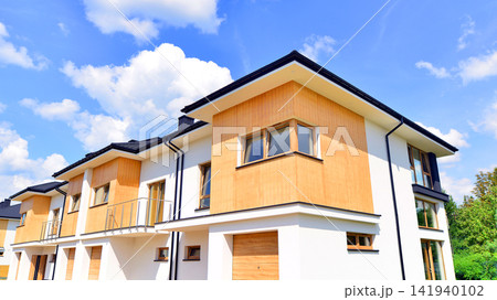New single family houses in a new development area. Residential homes with modern facade. The real estate market in the suburbs. Terraced family homes in newly developed housing estate. New single family houses in a new development area. Residential homes with modern facade. The real estate market in the suburbs. Terraced family homes in newly developed housing estate. 141940102