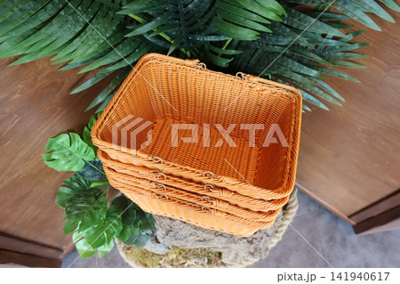 Wicker Baskets with Tropical Plants on Wooden Surface Wicker Baskets with Tropical Plants on Wooden Surface 141940617