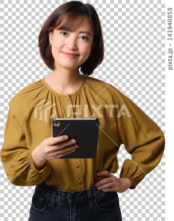 Asian woman holding tablet and smiling with confident professional expression in mustard blouse against transparent background 141940858