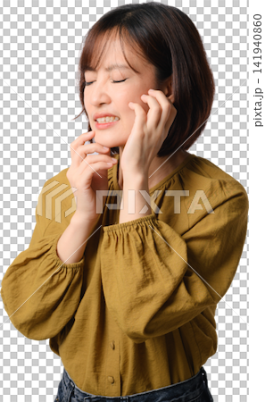 Asian woman with closed eyes touching face while wearing mustard blouse, expressing gentle discomfort in studio portrait Asian woman with closed eyes touching face while wearing mustard blouse, expressing gentle discomfort in studio portrait 141940860