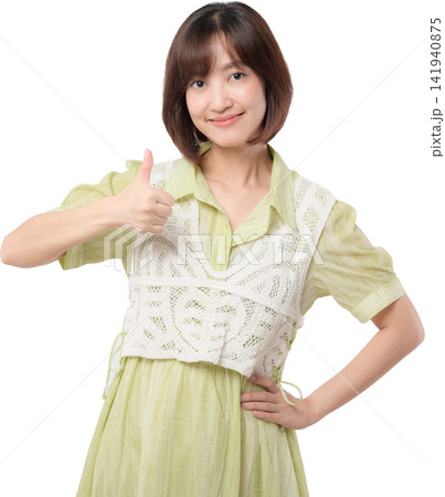 Asian woman giving thumbs up while wearing green dress and white lace vest with confident friendly expression isolated on transparent background 141940875