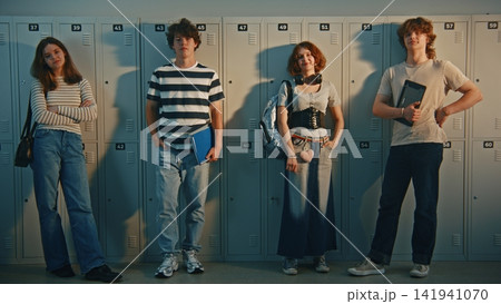 Trendy Teenage Students with Gadgets and Books Standing in Hallway 141941070