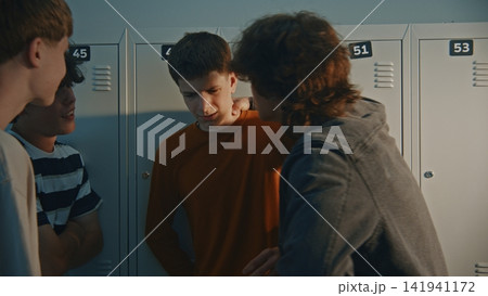 Group of Teenagers Bullying and Shoving Classmate by School Lockers Group of Teenagers Bullying and Shoving Classmate by School Lockers 141941172
