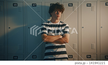 Worried Teenage Student Standing Alone Near School Lockers Worried Teenage Student Standing Alone Near School Lockers 141941221