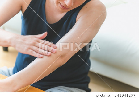 腕にクリームをなじませて微笑む男性のメンズボディケア顔なし 141941277
