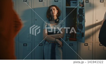 Teenage Schoolgirl Experiencing Panic Attack by Lockers in Crowded School Hallway 141941322