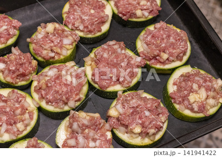 Putting Baking Sheet of Stuffed Zucchini Rounds Inside the Oven Putting Baking Sheet of Stuffed Zucchini Rounds Inside the Oven 141941422