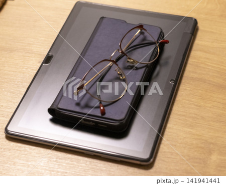Metal Framed Eyeglasses Resting on Digital Tablet Computer Case 141941441
