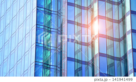 A modern tall building made of steel and glass, housing offices and financial institutions. Glass wall on the facade of the building. A modern tall building made of steel and glass, housing offices and financial institutions. Glass wall on the facade of the building. 141941499