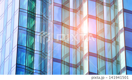 A modern tall building made of steel and glass, housing offices and financial institutions. Glass wall on the facade of the building. A modern tall building made of steel and glass, housing offices and financial institutions. Glass wall on the facade of the building. 141941501