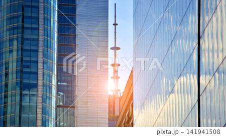 A modern tall building made of steel and glass, housing offices and financial institutions. Glass wall on the facade of the building. A modern tall building made of steel and glass, housing offices and financial institutions. Glass wall on the facade of the building. 141941508