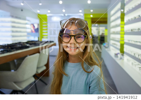 Stylish girl with teal shirt and glasses enjoying casual shopping experience Stylish girl with teal shirt and glasses enjoying casual shopping experience 141941912