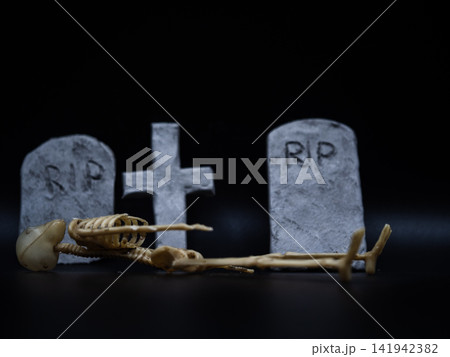 Skeleton in Halloween cemetery black background 141942382