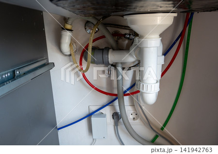 Plumbing pipes and drainage system under kitchen sink Plumbing pipes and drainage system under kitchen sink 141942763