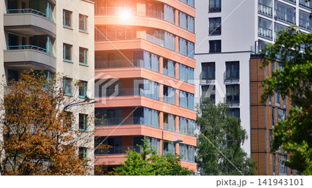 Modern residential building with new apartments in a green residential area. Eco architecture. Green tree and new apartment building. The harmony of nature and modernity. Modern residential building with new apartments in a green residential area. Eco architecture. Green tree and new apartment building. The harmony of nature and modernity. 141943101