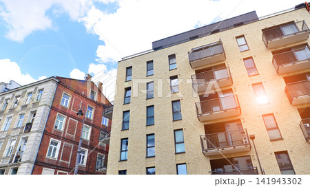 Modern apartment buildings on a sunny day with a blue sky. Facade of a modern apartment building.Glass surface with sunlight. Modern apartment buildings on a sunny day with a blue sky. Facade of a modern apartment building.Glass surface with sunlight. 141943302