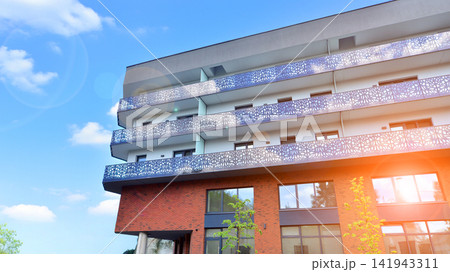 Modern apartment buildings on a sunny day with a blue sky. Facade of a modern apartment building.Glass surface with sunlight. Modern apartment buildings on a sunny day with a blue sky. Facade of a modern apartment building.Glass surface with sunlight. 141943311