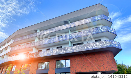 Modern apartment buildings on a sunny day with a blue sky. Facade of a modern apartment building.Glass surface with sunlight. 141943312