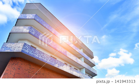 Modern apartment buildings on a sunny day with a blue sky. Facade of a modern apartment building.Glass surface with sunlight. 141943313