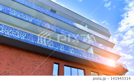 Modern apartment buildings on a sunny day with a blue sky. Facade of a modern apartment building.Glass surface with sunlight. Modern apartment buildings on a sunny day with a blue sky. Facade of a modern apartment building.Glass surface with sunlight. 141943314
