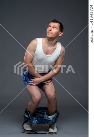 Anxious man in underwear with jeans pulled down looking up 141943724