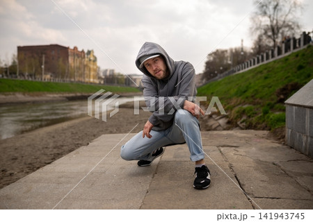 Breakdancer performing low ground move on concrete steps 141943745