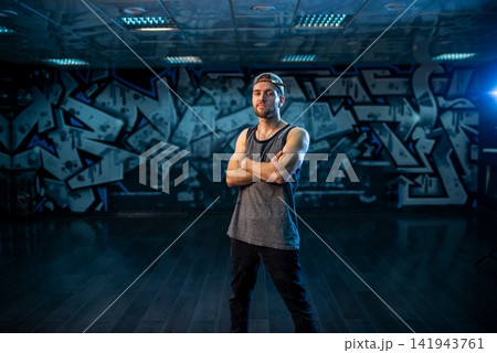 Bearded man standing with crossed arms inside dance studio Bearded man standing with crossed arms inside dance studio 141943761