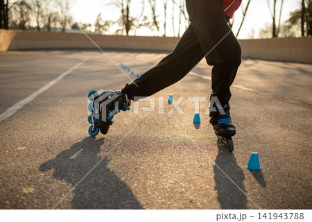 Tired rollerblader resting on a green wooden park bench 141943788