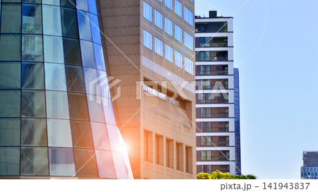 View of an new modern office building a with a glass facade standing next to modern apartment building. View of an new modern office building a with a glass facade standing next to modern apartment building. 141943837