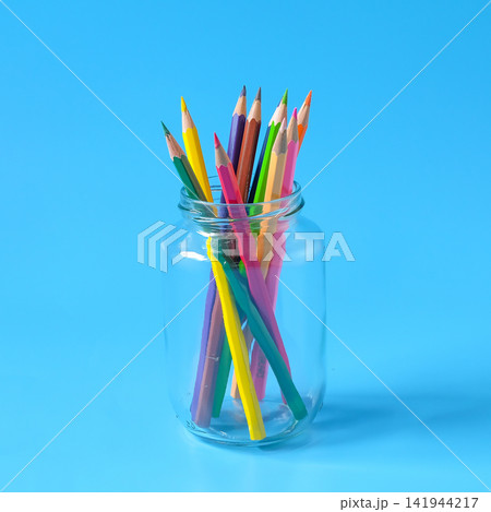 Color pencils in glass bottle on background. Color pencils in glass bottle on background. 141944217