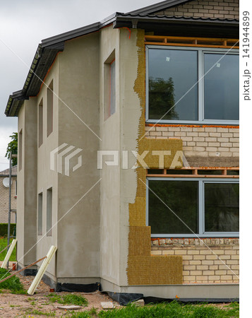 House Facade Renovation with Mineral Wool Insulation and Exterior Plaster During Energy Upgrade Work House Facade Renovation with Mineral Wool Insulation and Exterior Plaster During Energy Upgrade Work 141944899