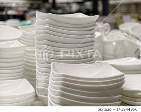 Ceramic plates bowls and salad bowls displayed in organized stacks on retail store shelving Ceramic plates bowls and salad bowls displayed in organized stacks on retail store shelving 141944956
