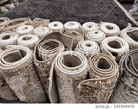Decorative shaggy carpets in warm hues laid out in a superstore offering soft textures and elegant floor design ideas, top view 141944976