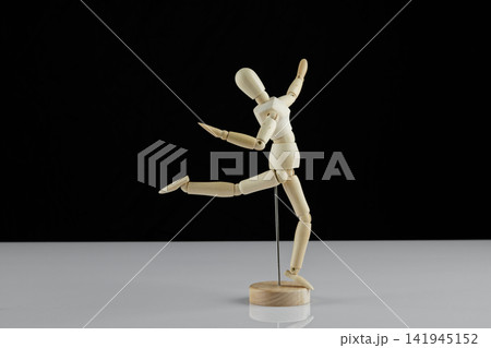 wooden human model poses on the table 141945152