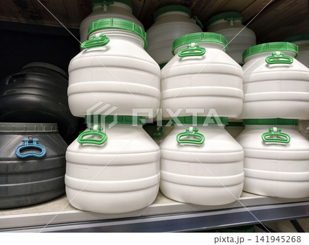 White and black barrels are neatly arranged on the shelves of a hardware store, perfect for any storage project White and black barrels are neatly arranged on the shelves of a hardware store, perfect for any storage project 141945268