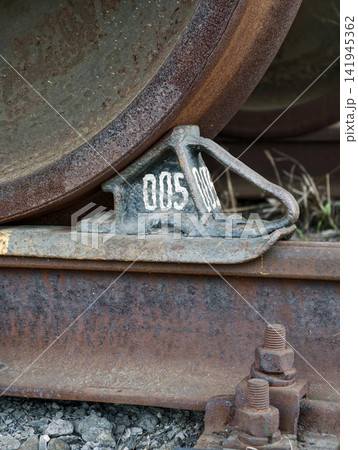 Cargo train wheel resting securely on brake chock preventing movement along railway lines Cargo train wheel resting securely on brake chock preventing movement along railway lines 141945362
