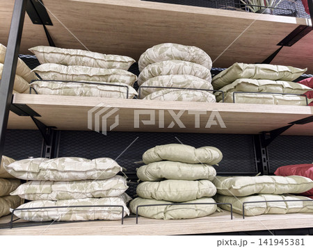 Chair cushions arranged on supermarket shelves with soft padded seat pads and home comfort textile assortment detail 141945381