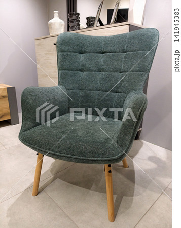 Elegant blue armchair with wooden legs for sale at the home decor shop Elegant blue armchair with wooden legs for sale at the home decor shop 141945383