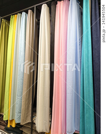 Curtains in vibrant colors neatly arranged for shoppers inside a store 141945504