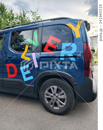 Car with eye catching colorful DELIVERY lettering parked along a residential street creating a clean visual representation of urban transportation and delivery activity Car with eye catching colorful DELIVERY lettering parked along a residential street creating a clean visual representation of urban transportation and delivery activity 141945519
