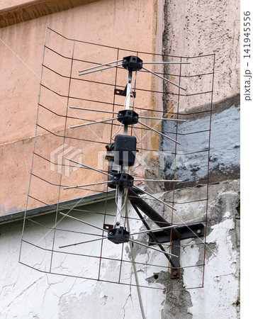 Old TV and radio aerial attached to exterior balcony showing traditional antenna design on apartment building Old TV and radio aerial attached to exterior balcony showing traditional antenna design on apartment building 141945556
